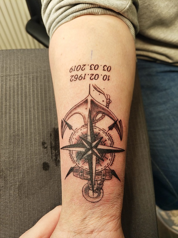 Tattoo eines Ankers mit einem Kompass mit Geburts und Sterbedatum