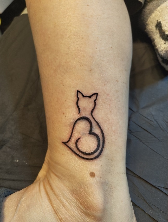 Coverup mit einer grafischen Katze auf dem Knöchel
