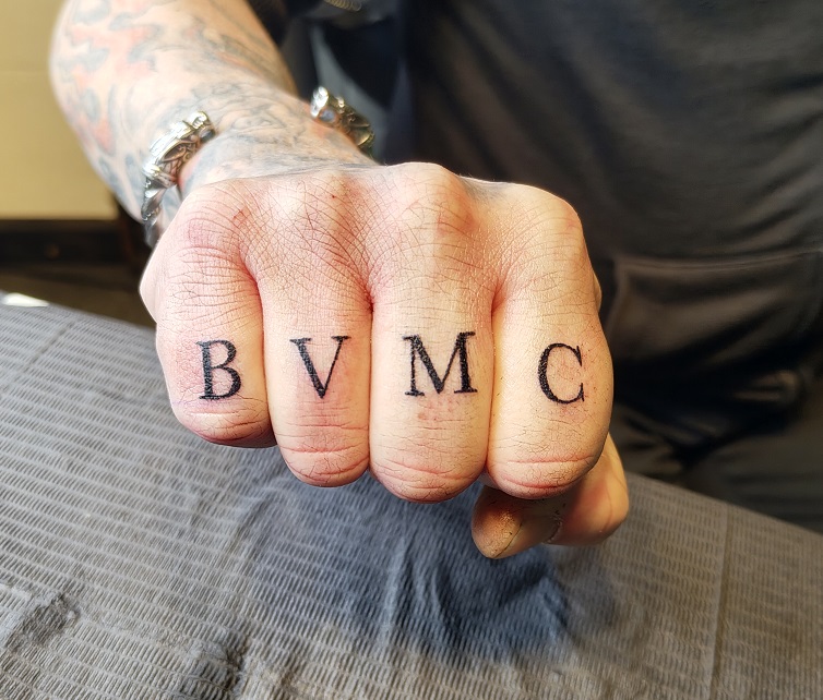 Tattoo von vier Buchstaben auf den Fingern