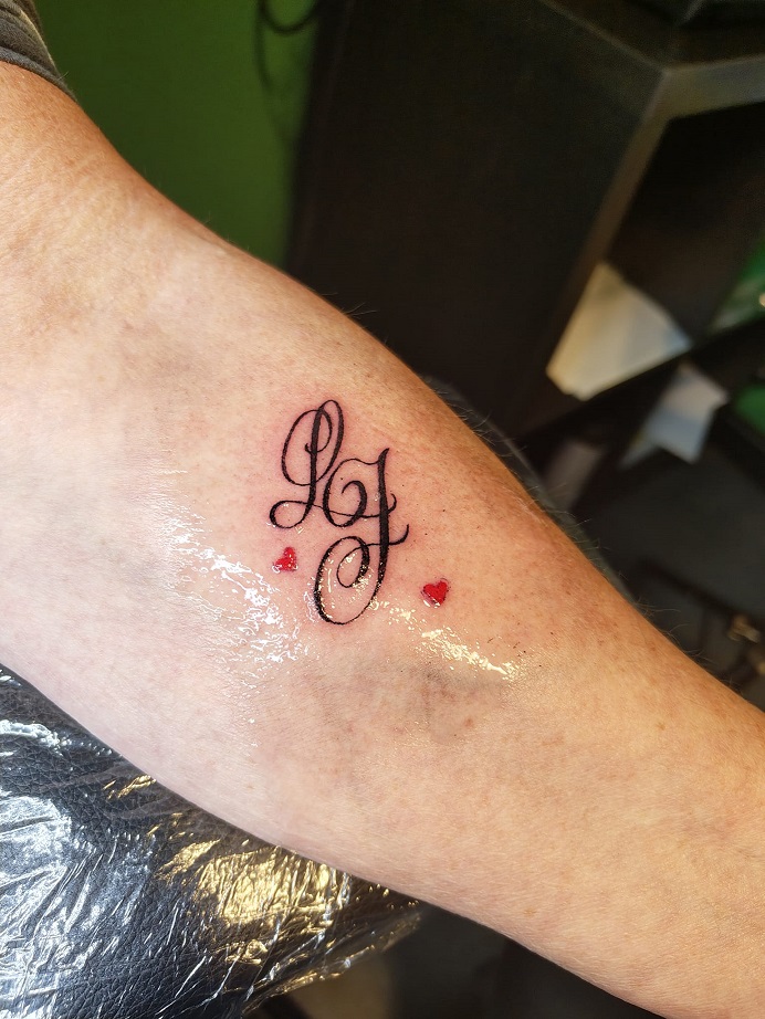 Tattoo von 2 filigranen Buchstaben am Unterarm
