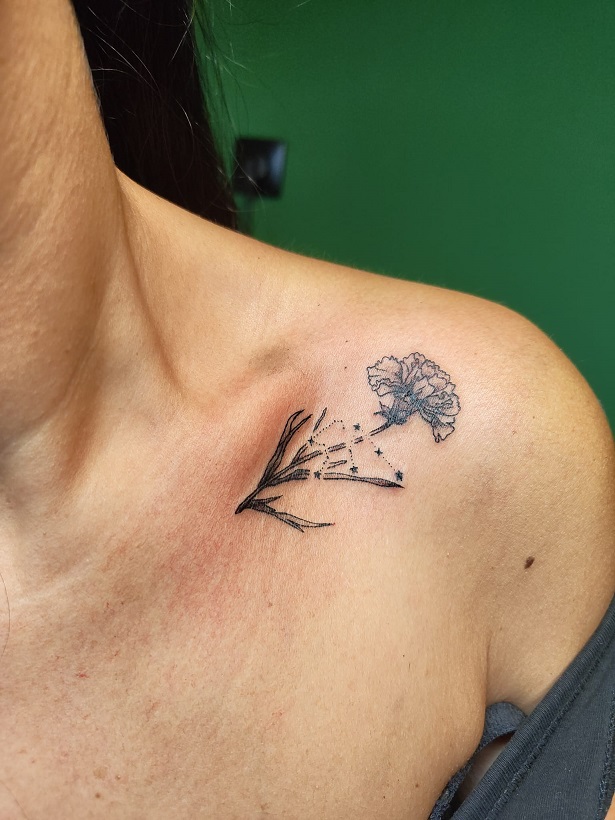 Tattoo einer Geburtsblume Nelke mit Sternzeichen Wassermann am Schlüsselbein