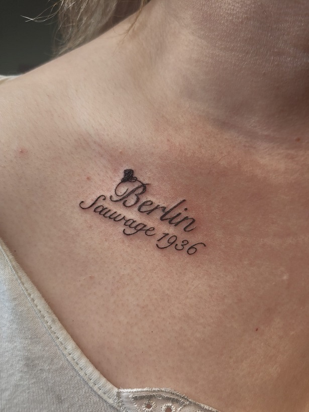 Tattoo der Schrift 'Berlin Sauvage' an der Brust