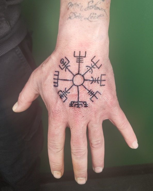 Tattoo eines Wegweiser im Vikinger-Stil auf dem Ha...